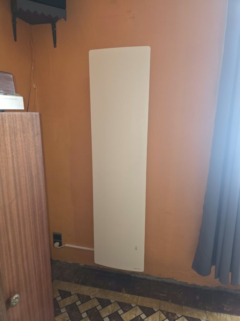 Radiateur électrique vertical Atlantic Agilia+ posé sur un mur orange à Pont-à-Celles
